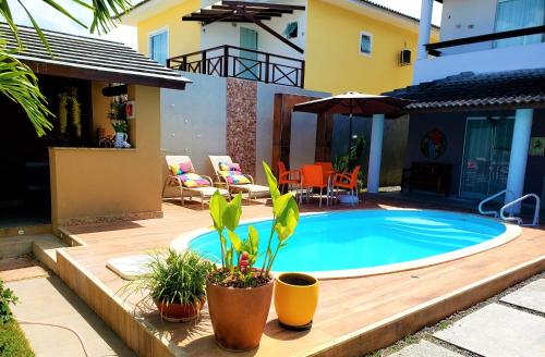 uma piscina num quintal com plantas e uma casa em Excelente Duplex em Arembepe Aquaville - Bahia em Salvador