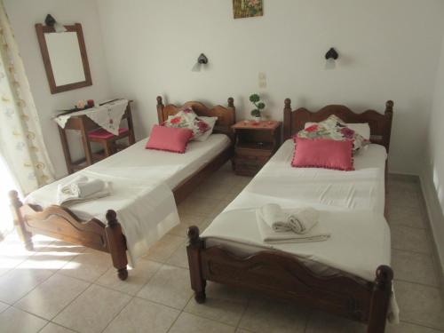 two beds sitting in a room with a mirror at Aris Paschalia Studios in Argyrádes