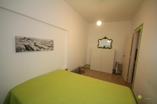 a bedroom with a green bed and a refrigerator at Big Alface in Lisbon