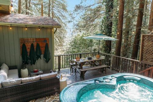 a hot tub on a deck with a table and bench at Artist's Perch in Guerneville