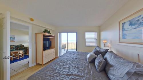 a living room with a couch and a television at Vistas on the Gulf by Travel Resort Services in St Pete Beach