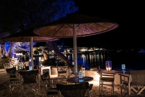 a table and chairs with an umbrella at night at Ostria Studios & Apartments in Aliki