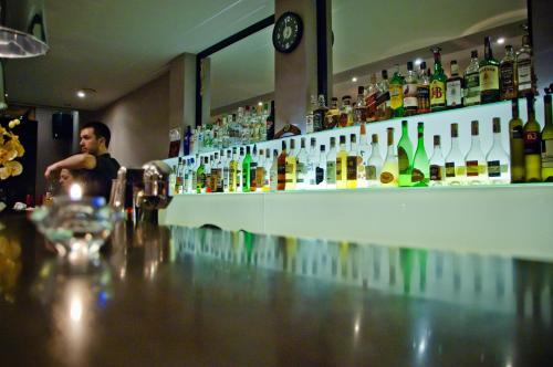 a man sitting at a bar with a counter full of alcohol at Luxor Complex in Ivaylovgrad