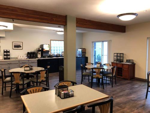 a restaurant with tables and chairs and a kitchen at Inn at Wecoma in Lincoln City