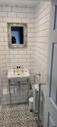 a white bathroom with a sink and a mirror at Pannett View - in the heart of Whitby in Whitby