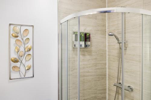 a shower with a glass door in a bathroom at Perfect Location with Parking - Jersey House - TV in every Bedroom! in Swansea