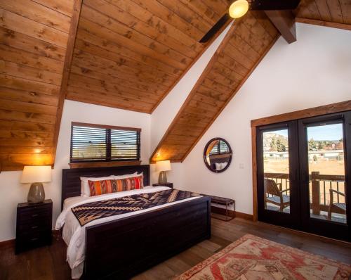 a bedroom with a large bed and wooden ceilings at Relax in Luxury - Jacuzzi, Indoor/Outdoor Fireplace in Estes Park