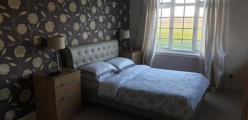 a bedroom with a bed and a window at Plumpton House in Ashford