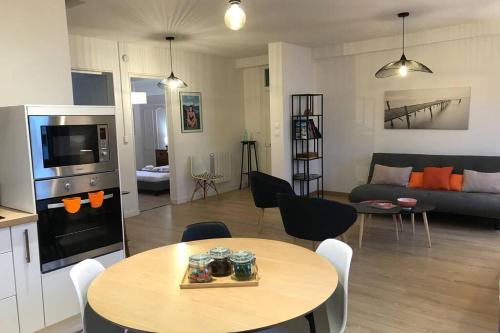 une cuisine et un salon avec une table et un canapé dans l'établissement LE COTEAU - centre ville, jardin & parking!, à Annecy