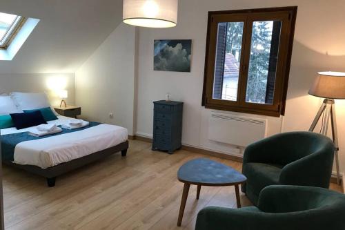 une chambre avec un lit, une chaise et une fenêtre dans l'établissement LE COTEAU - centre ville, jardin & parking!, à Annecy