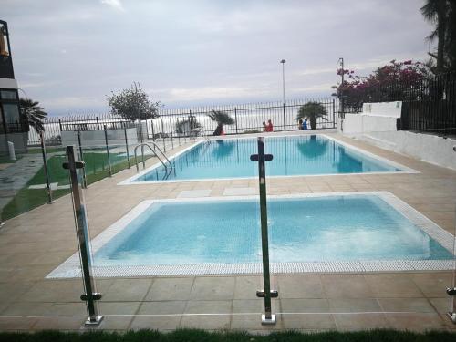 une grande piscine à côté de l'océan dans l'établissement Apartamentos Corona Playa, à Playa del Ingles