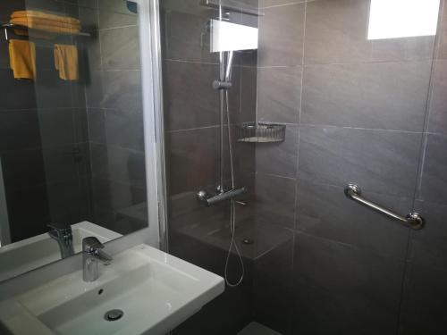 y baño con lavabo y ducha con espejo. en Apartamentos Corona Playa, en Playa del Inglés