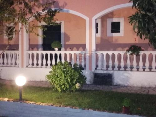 a house with a white fence and a porch at Aris Paschalia Studios in Argyrádes