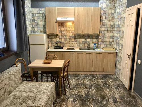 a kitchen with a table and a kitchen with a table and chairs at Вілла Лісова комфорт in Skhidnitsa