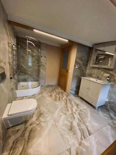 a bathroom with a marble floor and a toilet and sink at Seaside Apartments Roja in Roja