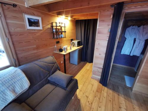 ein Wohnzimmer mit einem Sofa und einem Tisch in der Unterkunft Les cabanes du domaine de l Esperluette in Le Lauzet-Ubaye
