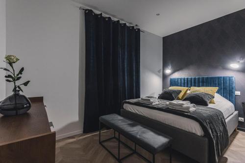 a bedroom with a bed with a blue headboard at Art Déco Gare & Spa in Reims