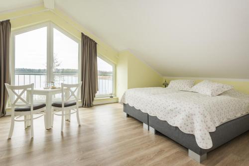 una camera con letto, tavolo e sedie di Luxus-See-Domizil mit Sauna, Kamin und Boot-130 qm für 6 Personen a Krakow am See