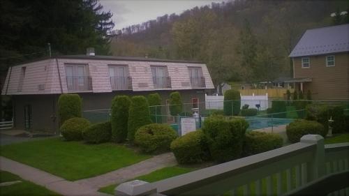 a house with a fence in front of a yard at Edelweiss Ski Lodge in Ellicottville