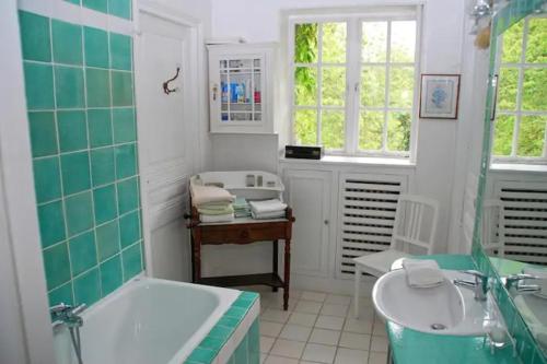 een groene en witte badkamer met een bad en een wastafel bij Les impressionnistes Maison de famille in Saint-Aubin-sur-Scie