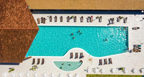 una vista aérea de una piscina con sillas y personas en Nauticomar Resort All Inclusive & Beach Club, en Porto Seguro