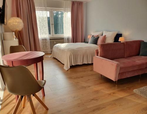 a bedroom with a bed and a couch and a table at Harmony Apartment in Gelsenkirchen