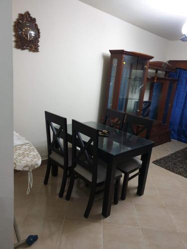 a dining room with a black table and chairs at sea view apartment in Porto Marina hotel tower in El Alamein