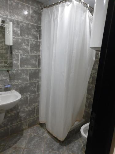 a bathroom with a shower curtain and a sink at sea view apartment in Porto Marina hotel tower in El Alamein