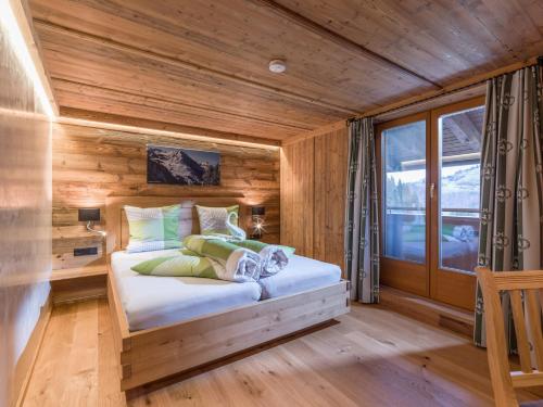 a bedroom with a bed in a wooden room at Achrainer-Moosen in Hopfgarten im Brixental