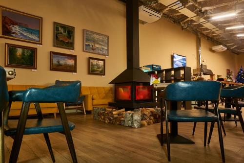 un bar con sillas azules y chimenea en Park Hotel Akter Ruza, en Staraya Ruza