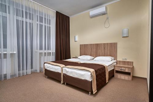 Un dormitorio con una cama grande y una ventana en Park Hotel Akter Ruza, en Staraya Ruza