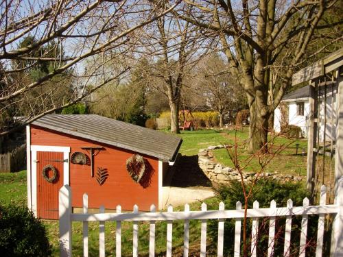 a small red dog house behind a white fence at 1825 Inn Bed and Breakfast in Palmyra