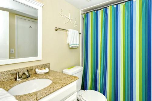 uma casa de banho com um lavatório e uma cortina de chuveiro em LaPlaya 101E-Relax on your private lanai under the palms! em Longboat Key