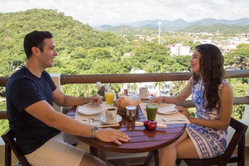 a man and woman sitting at a table with plates of food at Princess Mayev in Santa Cruz Huatulco