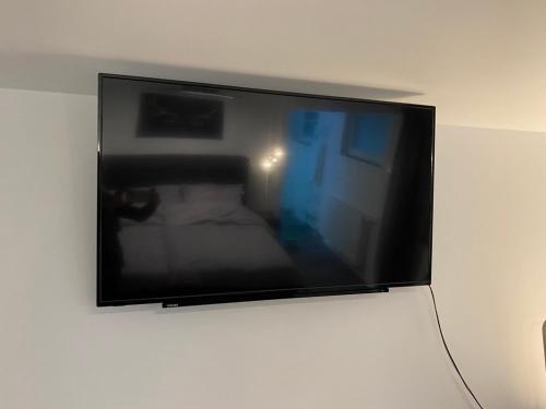 telewizor z płaskim ekranem wiszący na ścianie w obiekcie Luxus Appartement Kapstadt w mieście Bergisch Gladbach