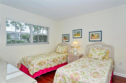 a bedroom with two beds and a window at LaPlaya 104E Perfectly located near the path to the beach just steps from the pool in Longboat Key
