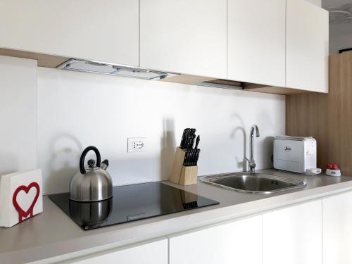 a kitchen with a sink and a tea kettle on a counter at Residence Aurora in Lavarone