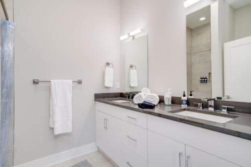 a white bathroom with a sink and a mirror at Mason Lofts at West End in Nashville