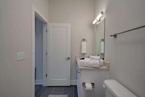 a white bathroom with a sink and a mirror at Mason Lofts at West End in Nashville