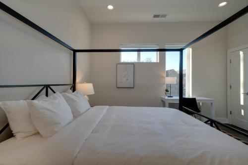 a bedroom with a large white bed and a window at Mason Lofts at West End in Nashville