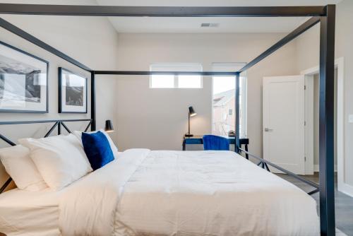 a bedroom with a large white bed with blue accents at Mason Lofts at West End in Nashville