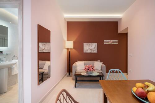 a living room with a table and a room with a couch at M City Apartments 100m from the beach in Chania Town