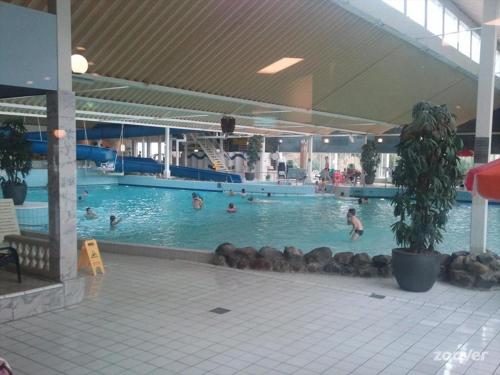 uma grande piscina com pessoas na água em Ostrea 14 Roompot beach resort Kamperland em Kamperland