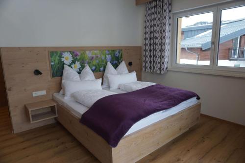 ein Schlafzimmer mit einem großen Bett und einem großen Fenster in der Unterkunft Appartements Blumenwiese in Ramsau am Dachstein