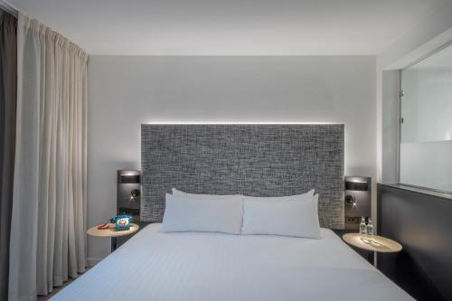 a bedroom with a large bed and two tables at INNSiDE by Meliá Newcastle in Newcastle upon Tyne