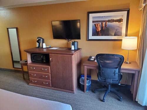 a hotel room with a desk with a television and a chair at Best Western The Westerly Hotel in Courtenay