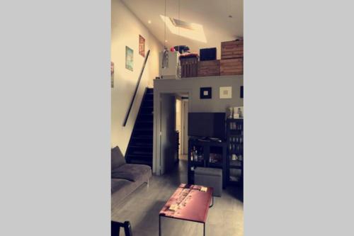 a living room with a couch and a table at Loft exceptionnel à Wépion avec jacuzzi extérieur l été et cabine infrarouge in Wépion