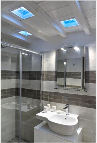 a bathroom with a sink and a shower and a mirror at Modern Cycladic Sea View House in Ornos