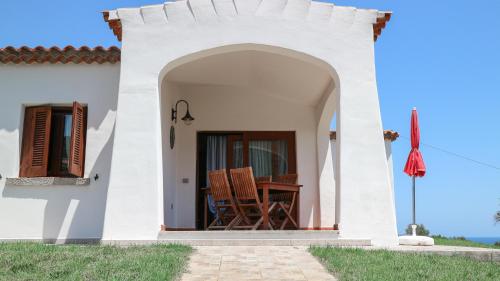 a small white house with a table and chairs at Marea in Tanaunella