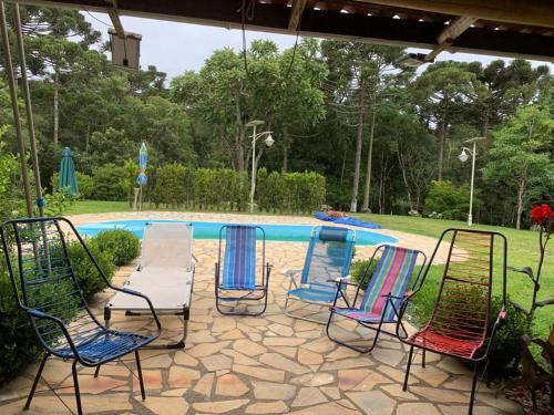 un grupo de sillas sentadas frente a una piscina en Chacara maravilhosa pertinho de Curitiba, en Curitiba